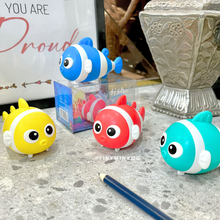 Load image into Gallery viewer, Four Colorful Fish 2 in 1 Sharpener And Eraser on a Surface With a Pencil and Decorative Vase in the Background - Tinyminymo