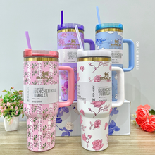 Load image into Gallery viewer, Four Colourful Floral Stanley Cups with Handles on a Wooden Surface - Tinyminymo