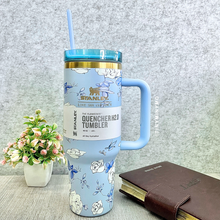 Load image into Gallery viewer, Blue Floral Stanley Cup with a Handle on a Grey Textured Surface, with a Plant and Book in the Background - Tinyminymo