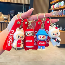 Load image into Gallery viewer, Four Labubu Coca-Cola Themed Keychains Held by a Hand - Tinyminymo