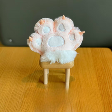 Load image into Gallery viewer, Peach Plush Paw 3D Keychain Shown on a Wooden Stool, Against a Dreamy Blurred Background - Tinyminymo