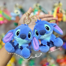 Load image into Gallery viewer, Two Blue Plush Stitch 3D Keychains Held in Hand Against a Blurred Background - Tinyminymo