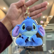 Load image into Gallery viewer, Blue Plush Stitch 3D Keychain Held by a Hand in an Indoor Setting - Tinyminymo