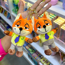 Load image into Gallery viewer, Two Plush Zootopia 3D Keychains Held by a Hand in Front of a Store Shelf - Tinyminymo