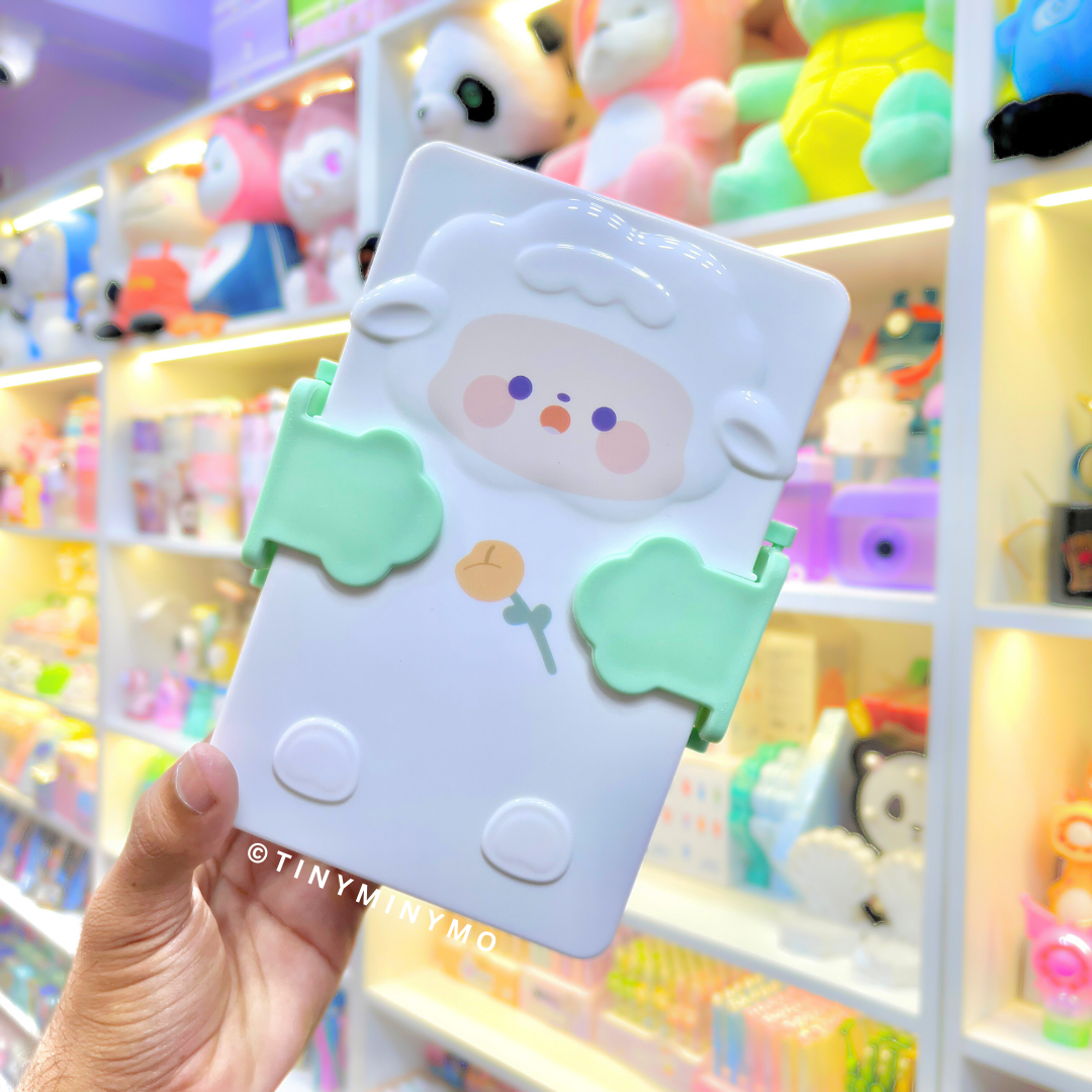 Green Adorable Sheep Snack Box held in front of a Colorful Toy Store Display - Tinyminymo