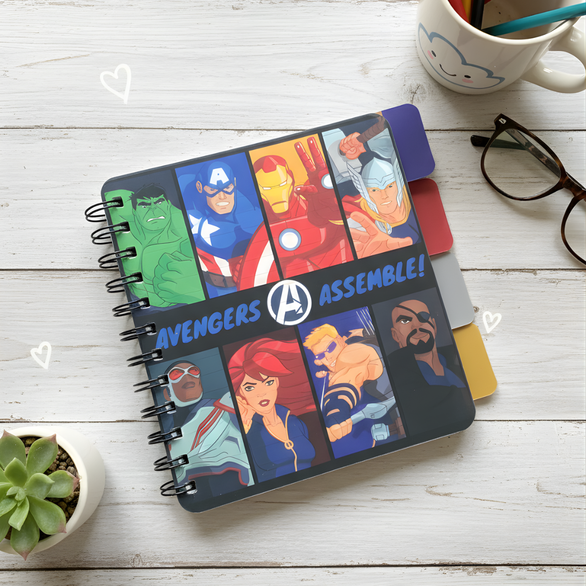 Notebook with Superhero Illustrations and 'Avengers Assemble!' text on a wooden surface - Tinyminymo