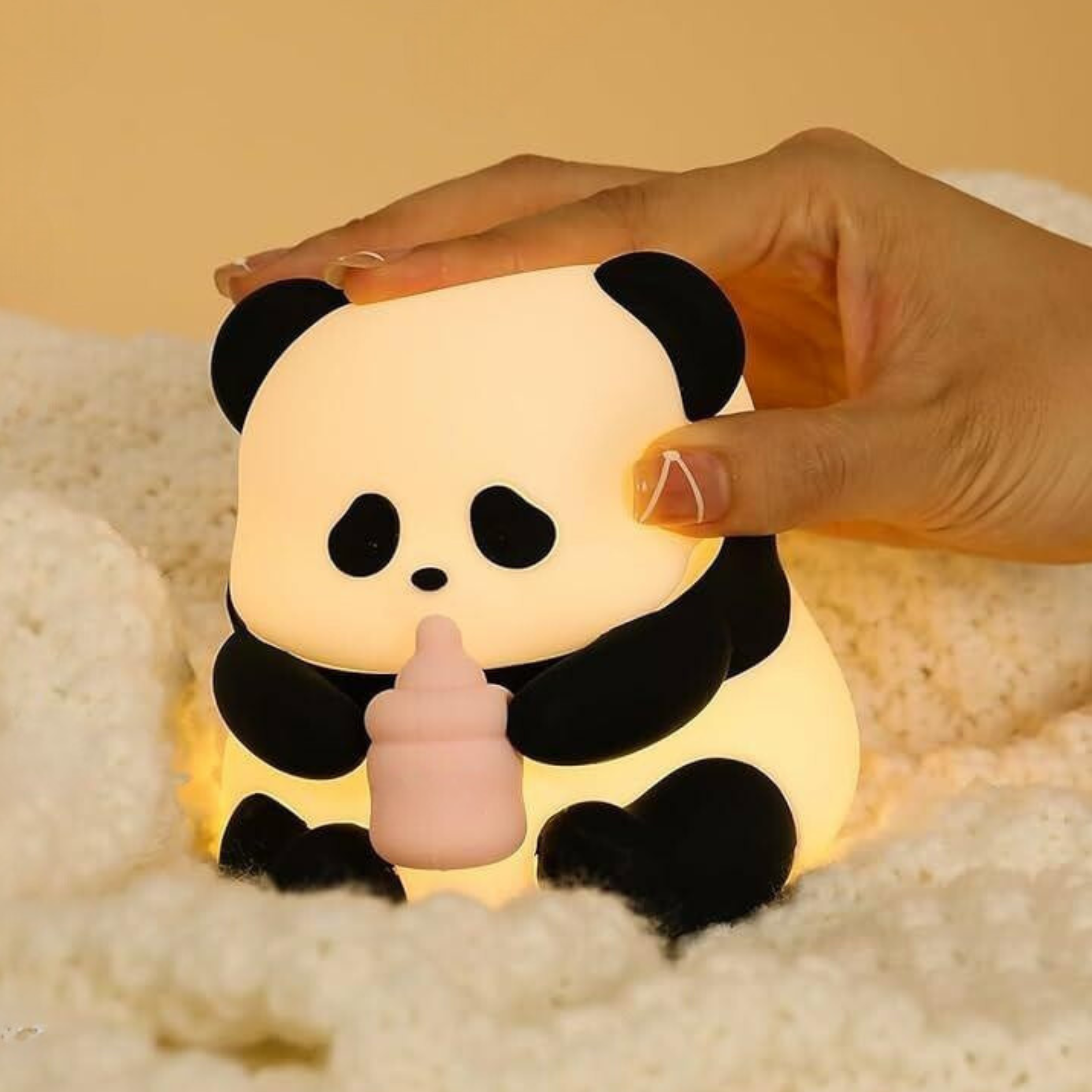 Baby Panda Silicone Night Light Held by a Hand on a Soft Surface - Tinyminymo