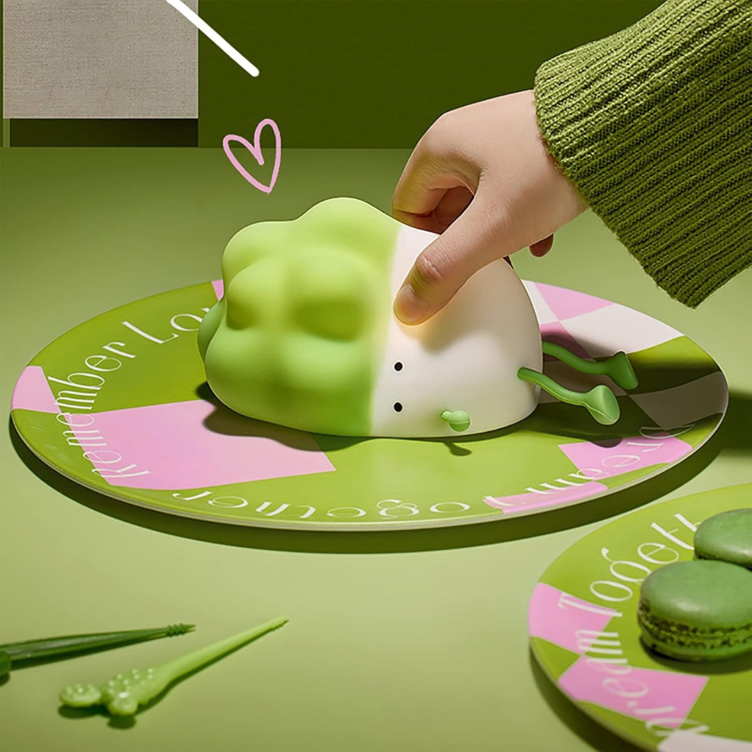 Hand Interacting with a Cabbage Silicone Night Light on a Green Surface with Decorative Elements - Tinyminymo