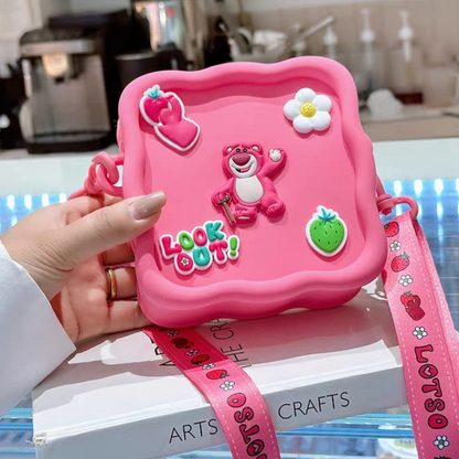 Lotso Silicone Sling Bag, Held in a Hand Above a Book - Tinyminymo