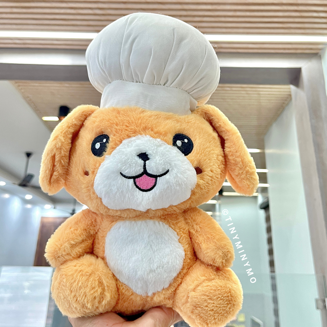 Chef Puppy Soft Toy held in Front of a Blurred Indoor Background - Tinyminymo