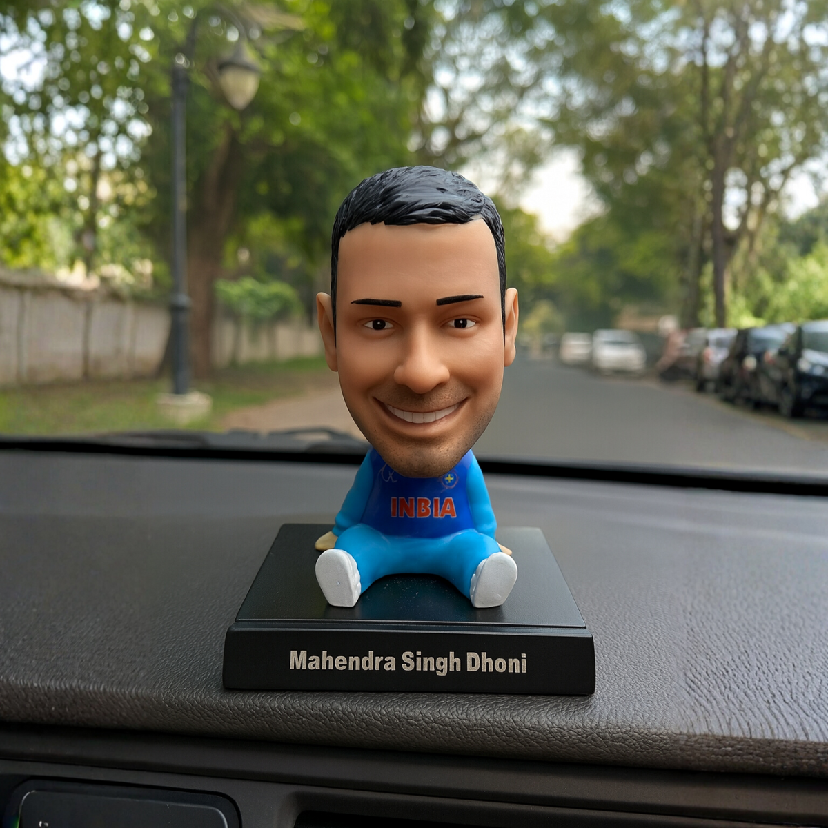 Bobblehead of Mahendra Singh Dhoni on a car dashboard - Tinyminymo