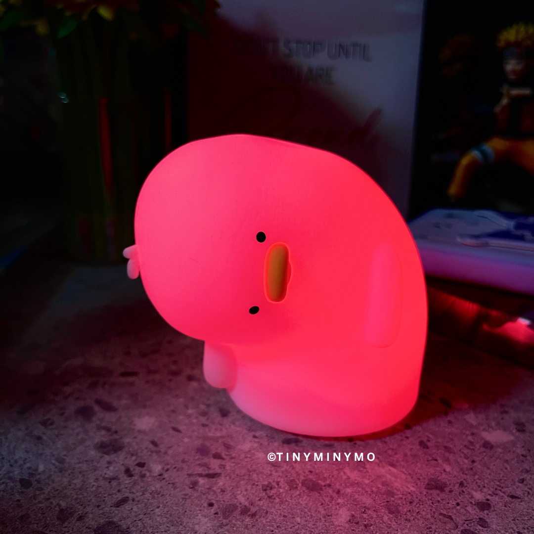 Crooked Neck Duck Silicone Night Light Glowing Red in Dark Background with Naruto Action Figure and Some Books at the Side - Tinyminymo