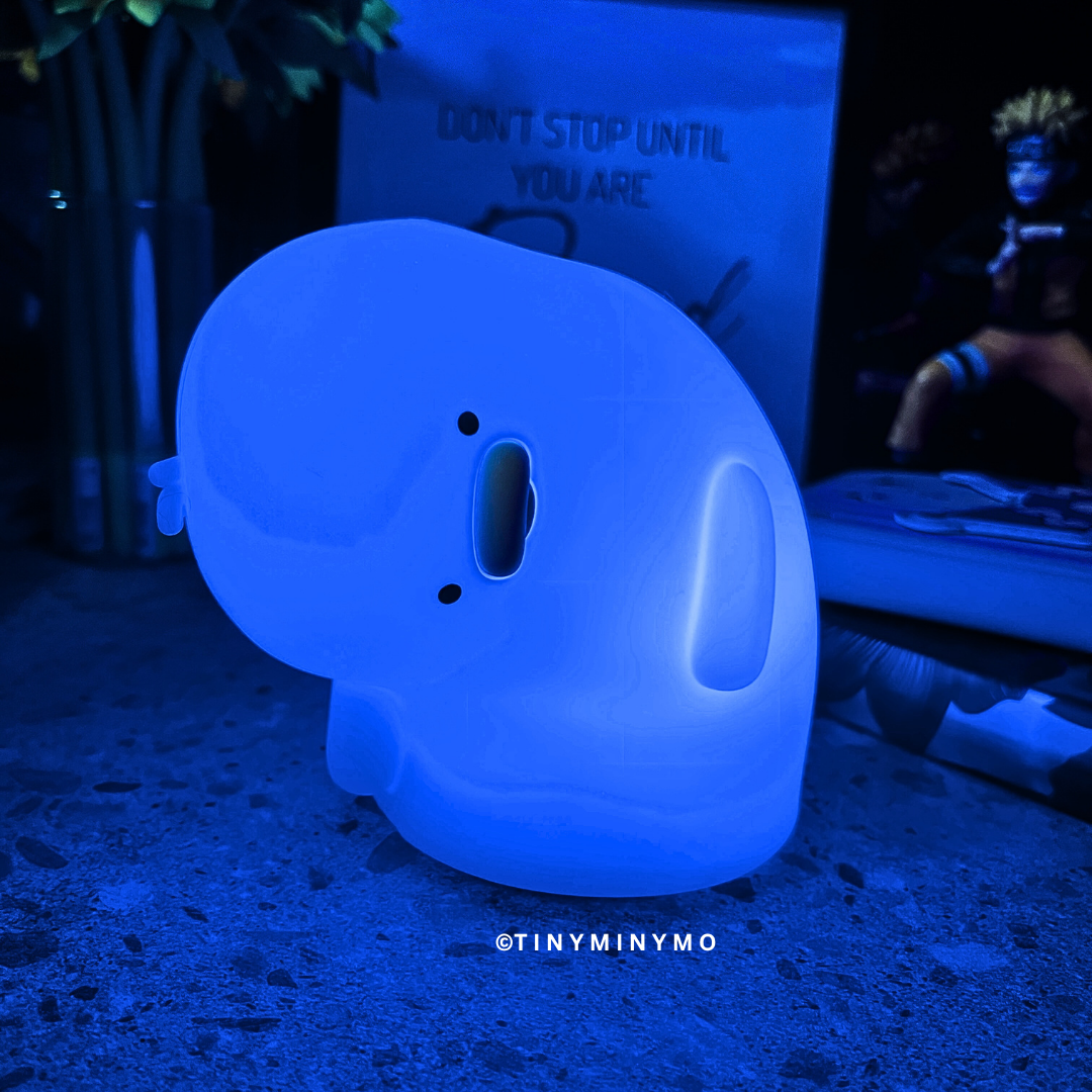 Crooked Neck Duck Silicone Night Light Glowing Blue in Dark Background with Naruto Action Figure and Some Books at the Side - Tinyminymo