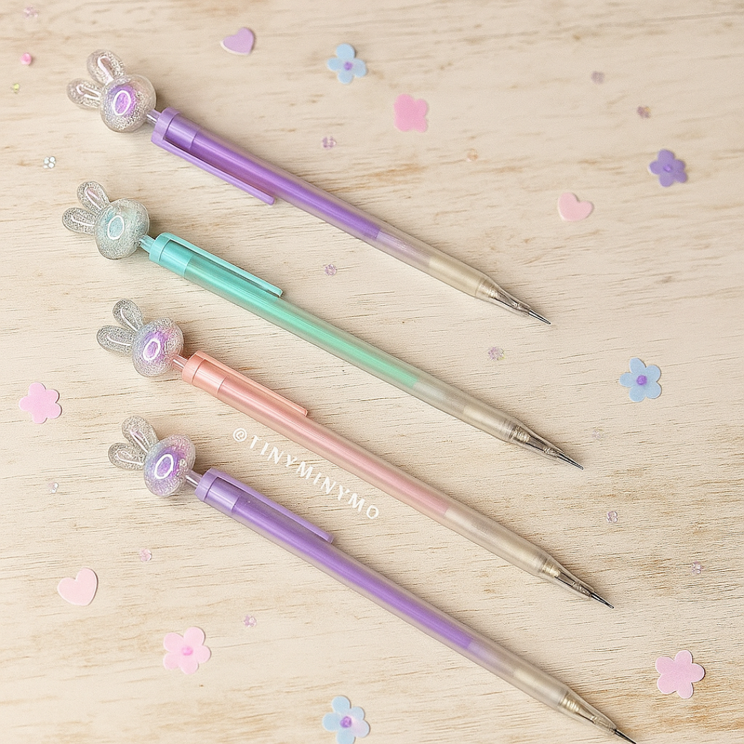Four pastel-colored Crystal Bunny Mechanical Pencil on a Wooden Surface with Decorative Flowers - Tinyminymo