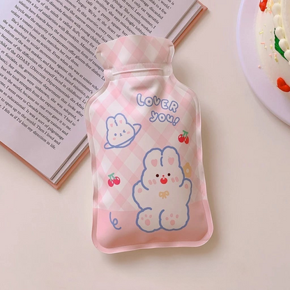 Pink Cute Hot Water Bag with cartoon print  on a light surface against to an open book - Tinyminymo