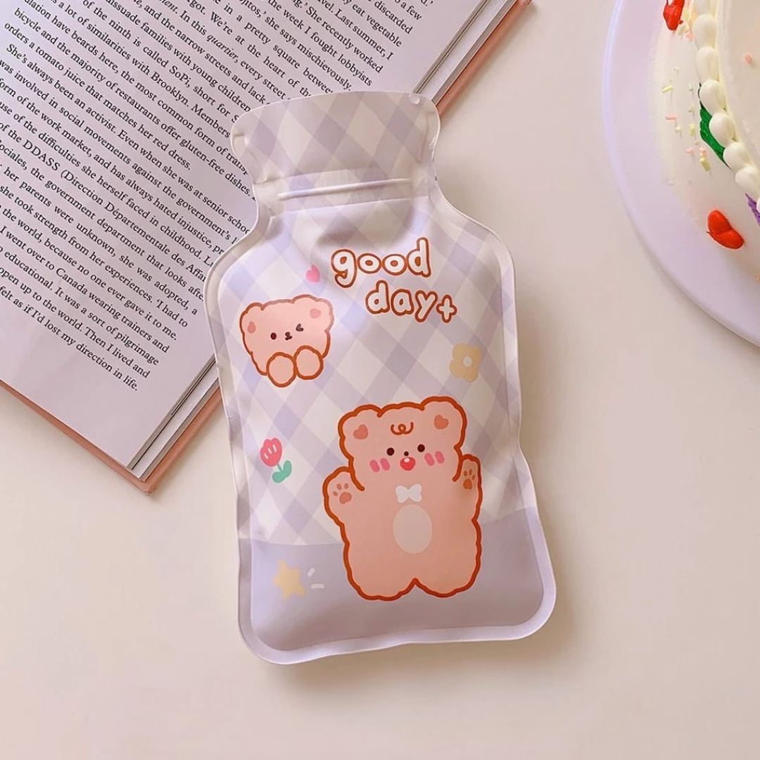 Cute Hot Water Bag with bear illustrations and 'good day' text on a light surface with a Book and Cake - Tinyminymo
