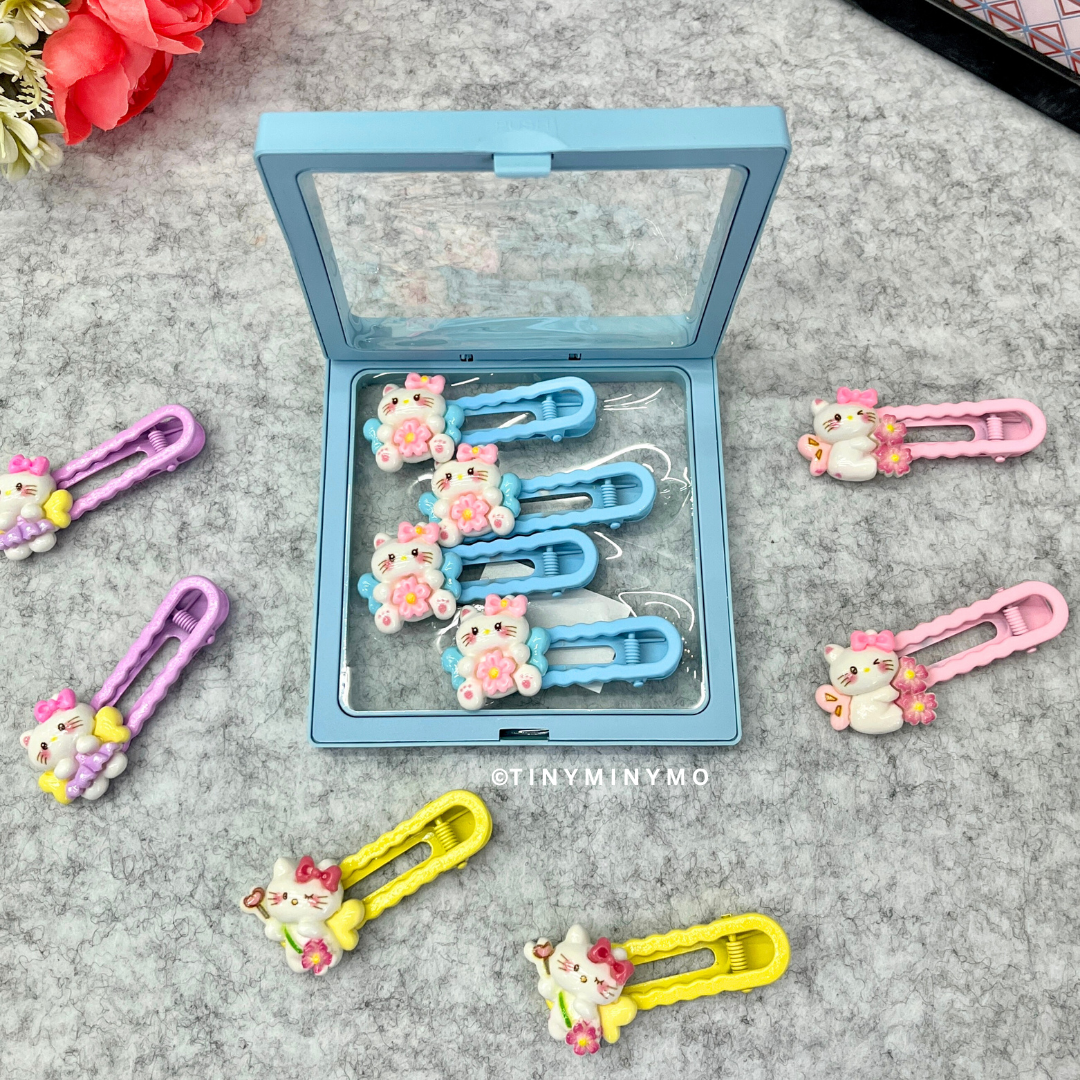 Colorful Cute Kitty Hair Clips in a Blue Case Placed on a Grey Surface - Tinyminymo