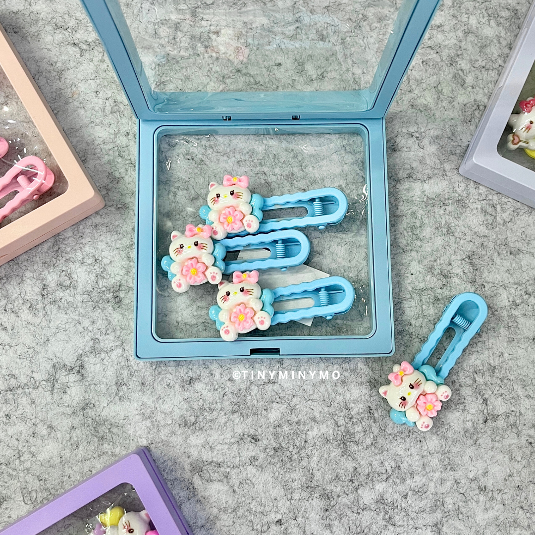 Set of Blue Cute Kitty Hair Clips with Clear Display Case Placed on a Textured Grey Surface - Tinyminymo