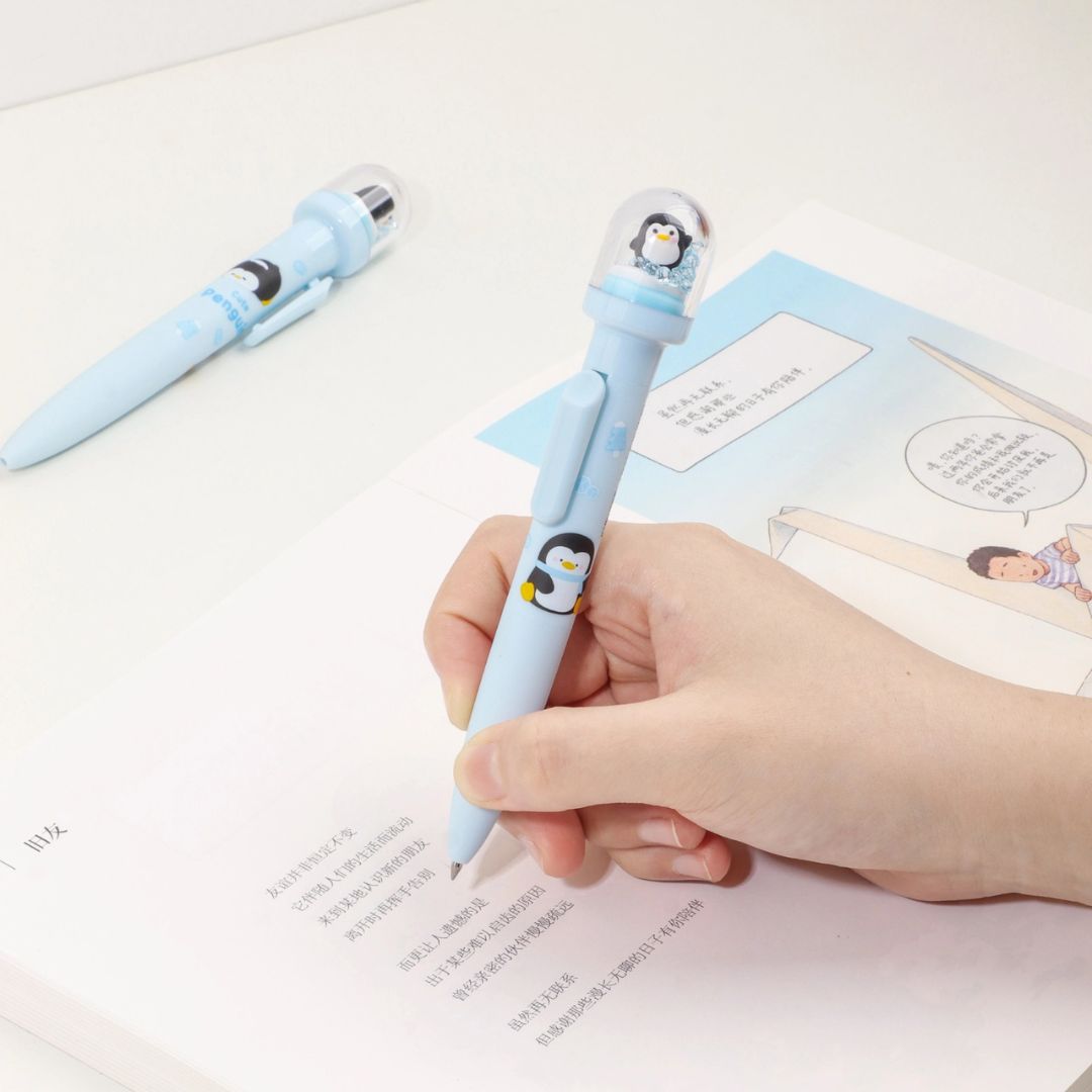 Penguin Design Pen Held by a Hand on a Book - Tinyminymo