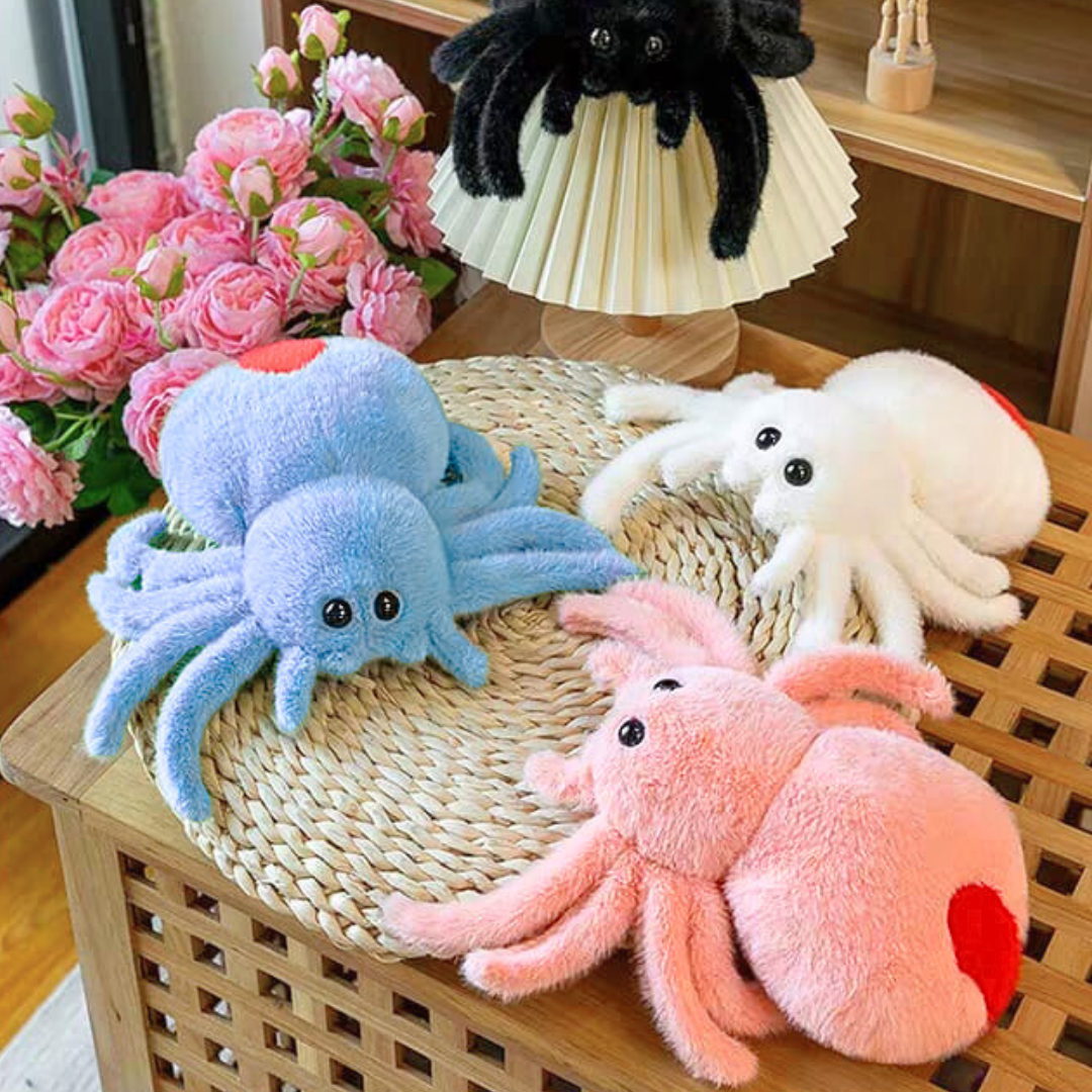 Cute Spider Soft Toy in Blue, Pink and White on a woven surface with flowers in the background - Tinyminymo