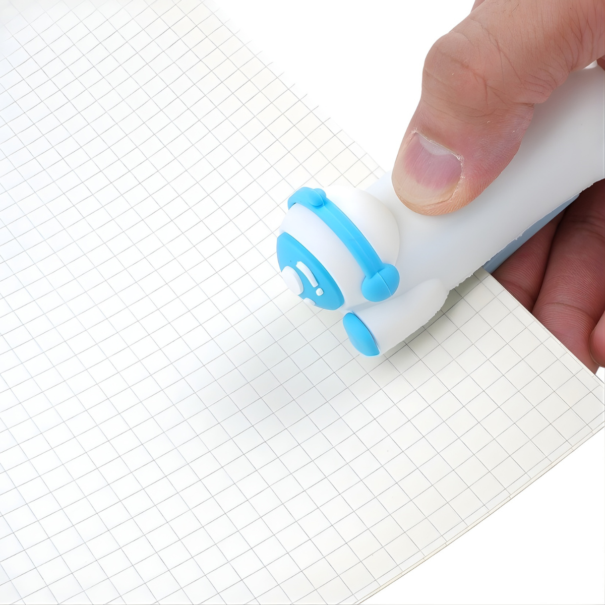 Blue Astronaut Stapler Held by a hand on a Grid Paper - Tinyminymo