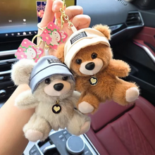 Load image into Gallery viewer, Two Cute Teddy Plush Keychain with hats held in front of a car interior - Tinyminymo
