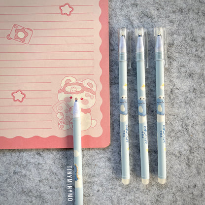 Blue Dinosaur-Themed Pens on a Grey Surface with a Pink Notebook - Tinyminymo