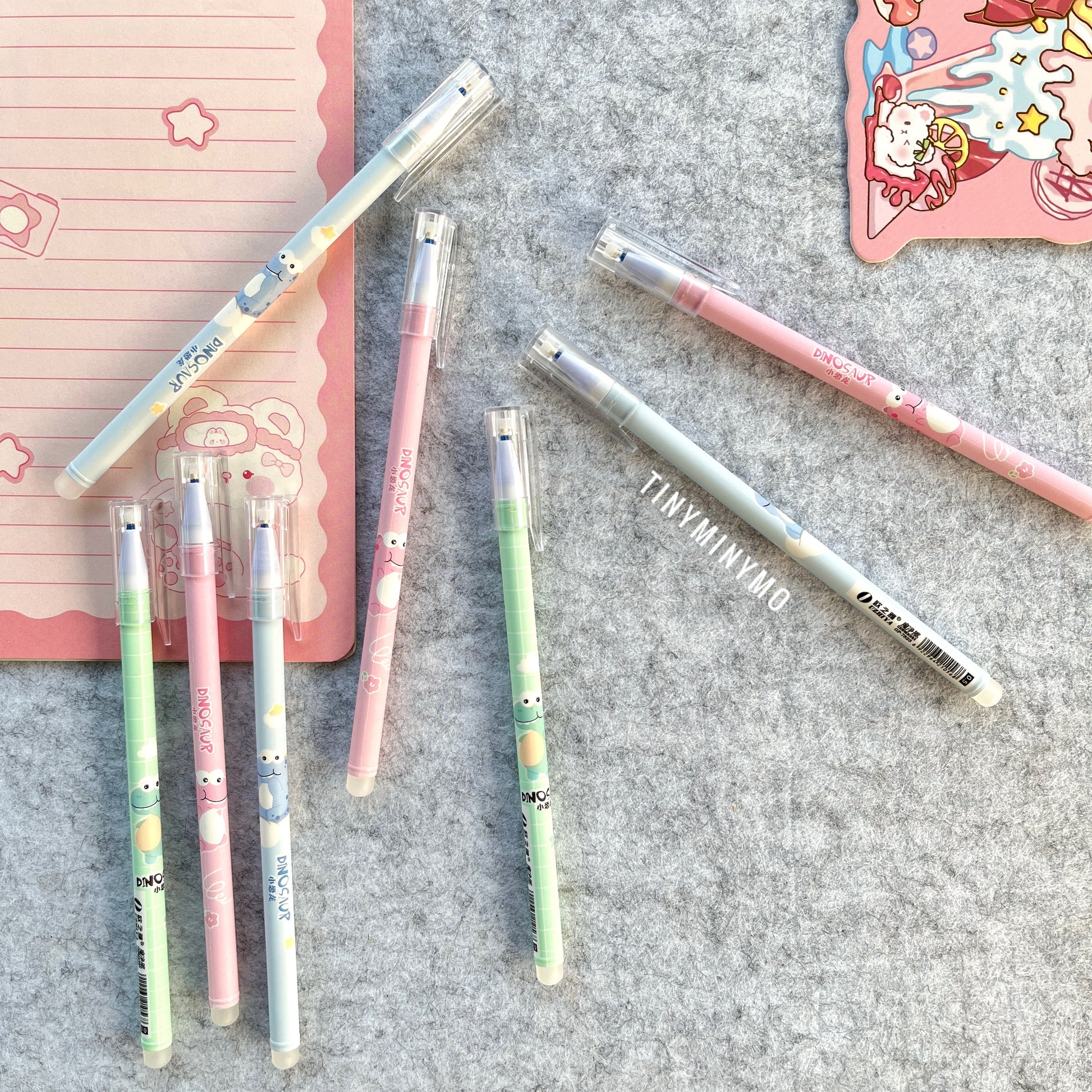 Set of Colorful Dinosaur Pens with Dinosaur Print on a Grey Surface - Tinyminymo