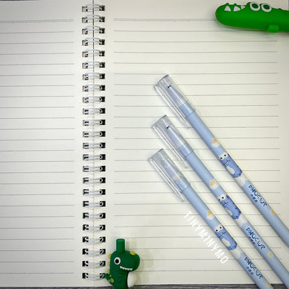 Three Blue Pens with Dinosaur Designs on a Lined Notebook Page - Tinyminymo
