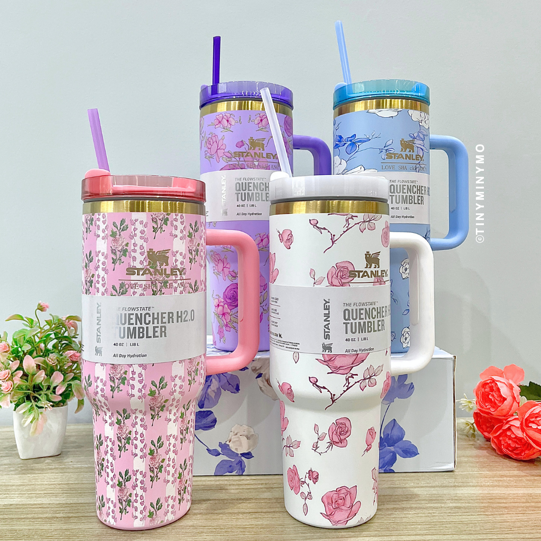 Four Colourful Floral Stanley Cups with Handles on a Wooden Surface - Tinyminymo
