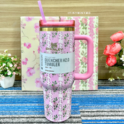 Pink Floral Stanley Cup on a Blue Textured Surface with Flowers in the Background - Tinyminymo