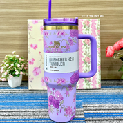 Purple Floral Stanley Cup with Purple Handle on a Blue Textured Surface - Tinyminymo