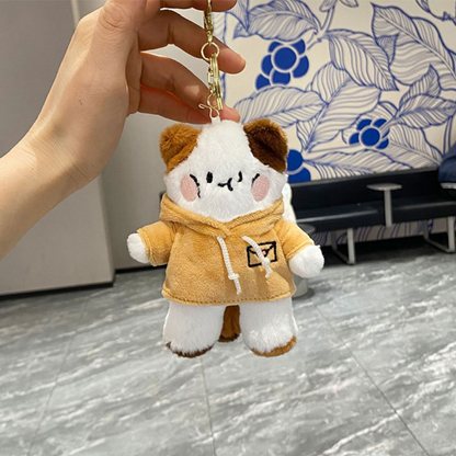 A Hand Holding a Kitty in Hoodie Plush Keychain Wearing a Yellow Hoodie Against a Floral Background - Tinyminymo