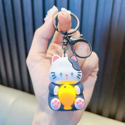 A Hand Holding a Cute Navy Blue Lightup Cat Keychain with a Fish - Tinyminymo