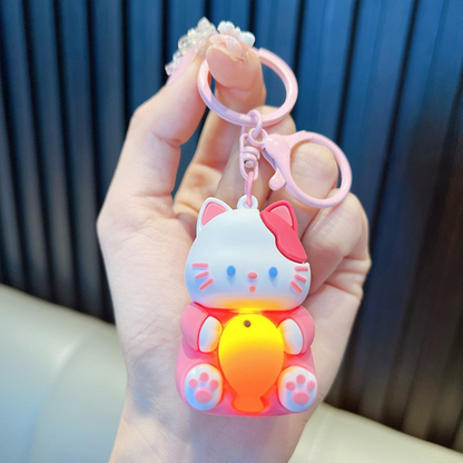 A Hand Holding a Pink Lightup Cat Keychain with a Yellow Fish - Tinyminymo
