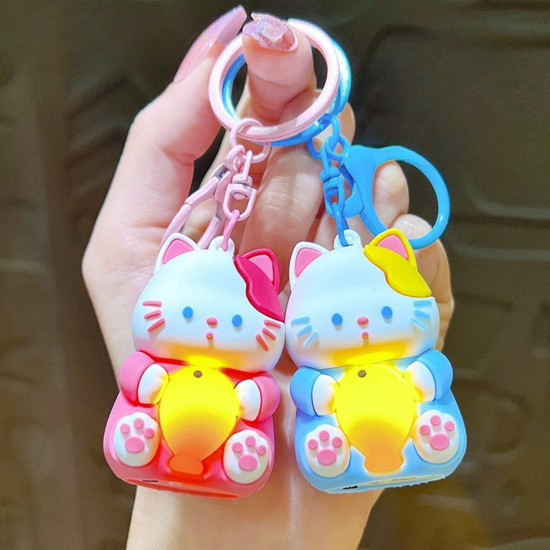 A Hand Holding Two Different Colored Lightup Cat Keychain with a Yellow Fish - Tinyminymo