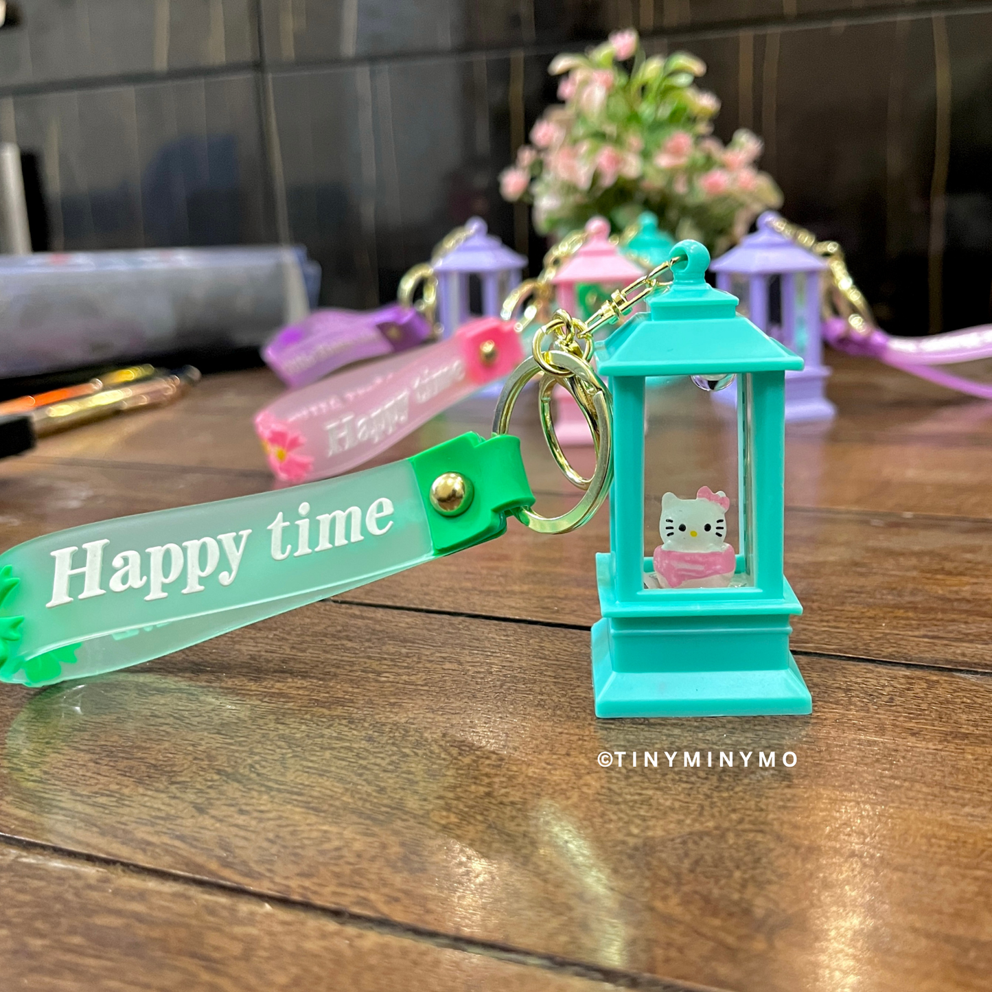 Lightup Sanrio Keychain Featuring Hello Kitty Character, Placed on a Wooden Surface - Tinyminmo
