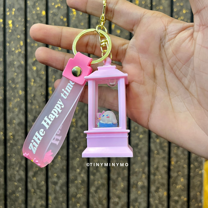 Pink Lightup Sanrio Keychain with a Small Cinnamoroll Figure, Held by a Hand Against a Wooden Background - Tinyminymo