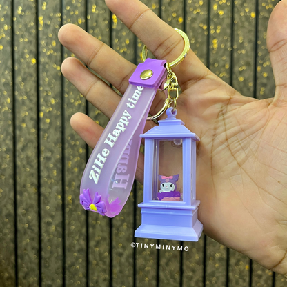 Purple Lightup Sanrio Keychain with a Small Lantern and Kuromi, Held in a Hand Against a Wooden Background - Tinyminymo