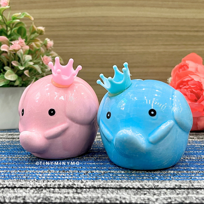 Pink and blue elephant-shaped figures with crowns on a textured surface - Tinyminymo