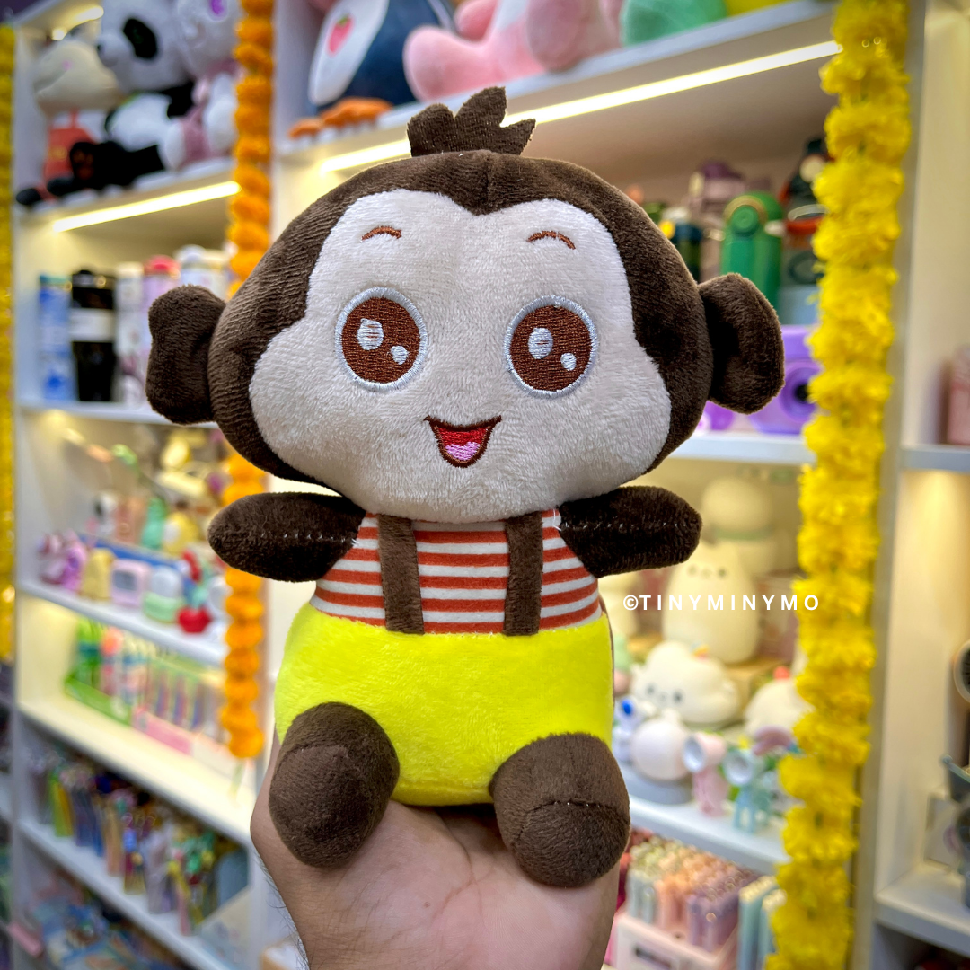 Little Monkey Soft Toy in Dark Brown Color held in front of a store shelf - Tinyminymo