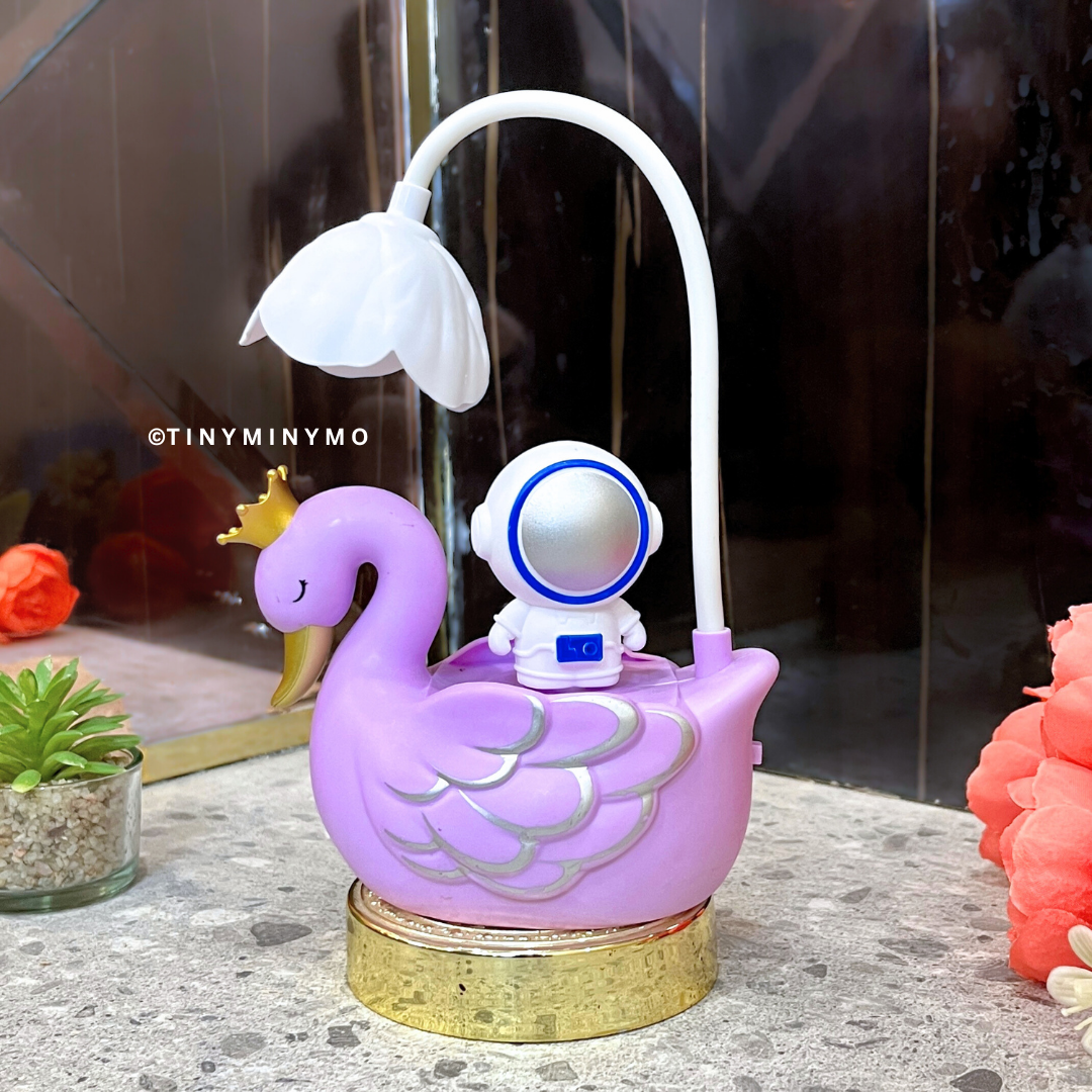 Purple Multifunctional Duck LED Desk Lamp with a Small Astronaut Figure on a Textured Surface - Tinyminymo