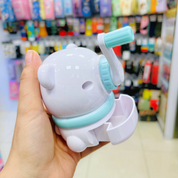 Hand holding a white and light blue Panda Mechanical Sharpener with a blurred store background - Tinyminymo