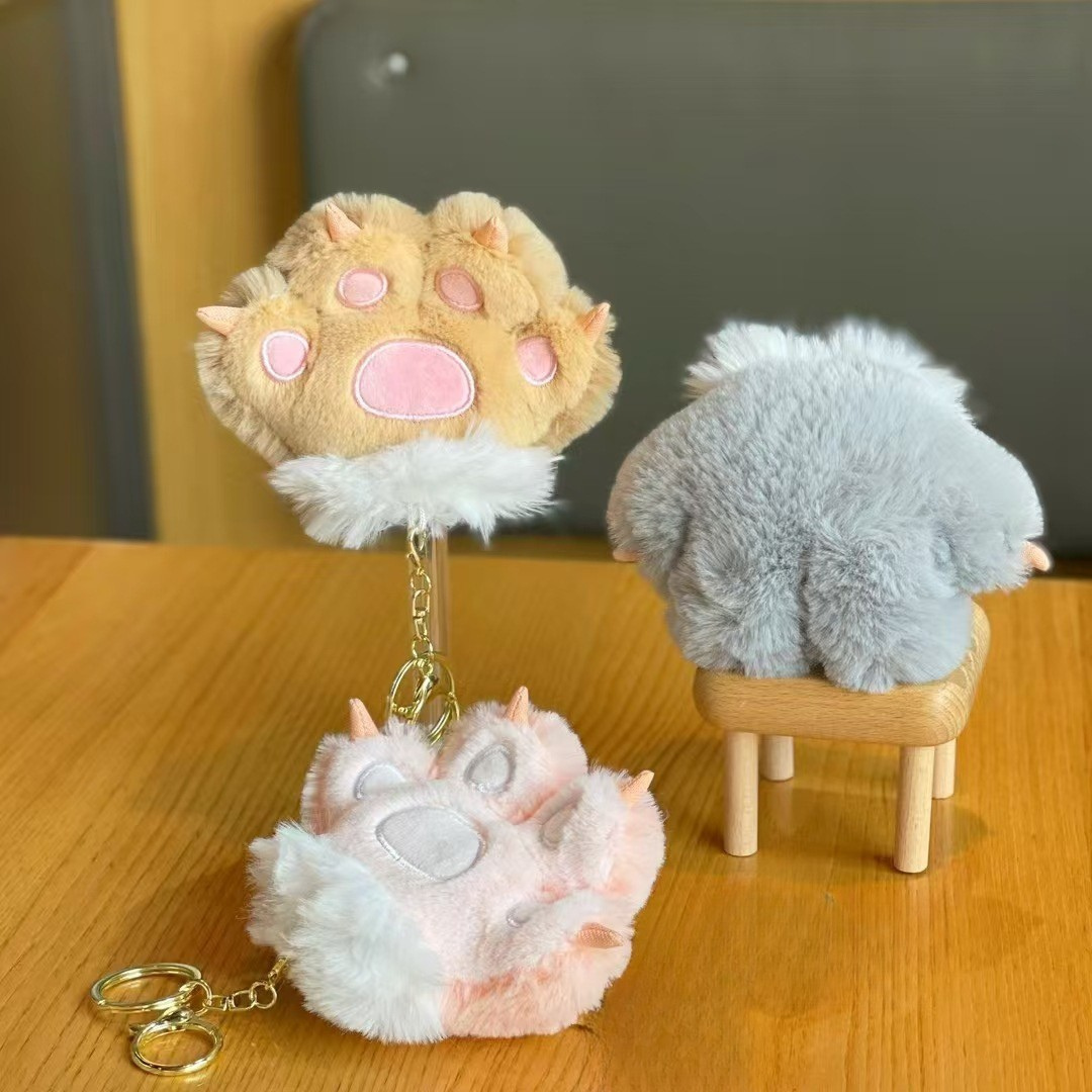 A Plush Paw 3D Keychain Resting on a Wooden Surface, with a Softly Blurred Background that Highlights its Fluffy Texture and Adorable Charm - Tinyminymo