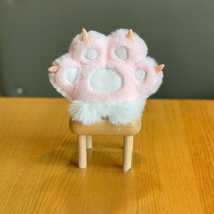 Soft and Adorable – Pink Plush Paw 3D Keychain on a Wooden Stool with a Neutral Background - Tinyminymo