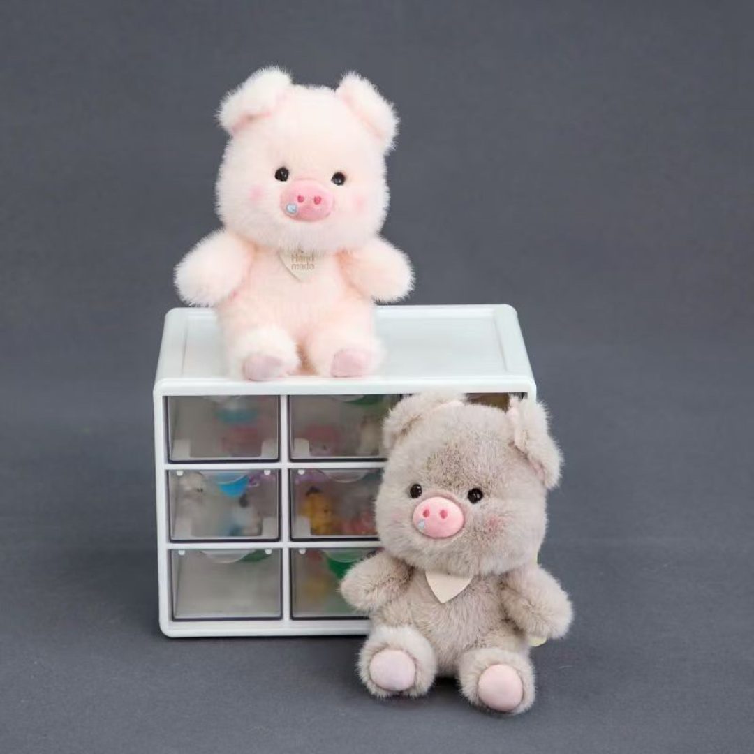 Plush Piggy 3D Keychains One Pink and One Greige  Displayed on a White Drawer Against a Dark Background - Tinyminymo