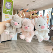 Three Plush Piggy 3D Keychains in a Frame Held by a Person Against an Office Background - Tinyminymo