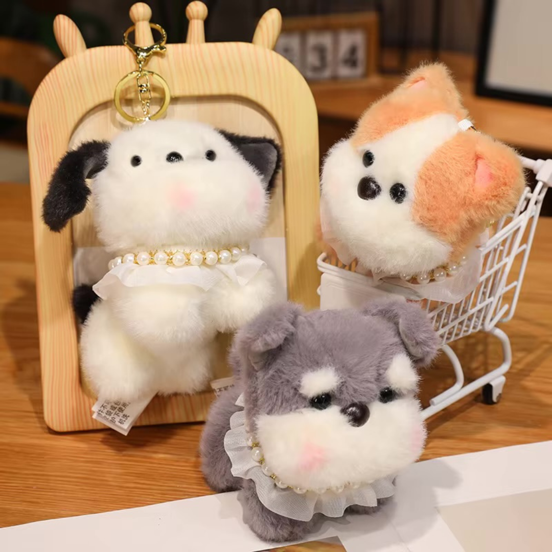 Three Pretty Puppy Plush Keychain in front of a Wooden Frame with a Keychain, on a Wooden Surface - Tinyminymo
