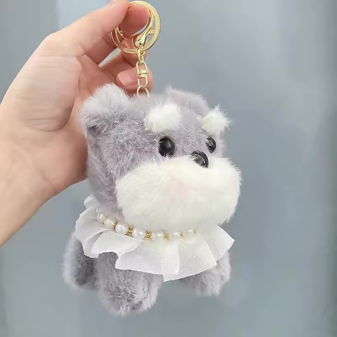Pretty Puppy Plush Keychain in Grey Color  with a Pearl Necklace held by a hand against a grey background - Tinyminymo