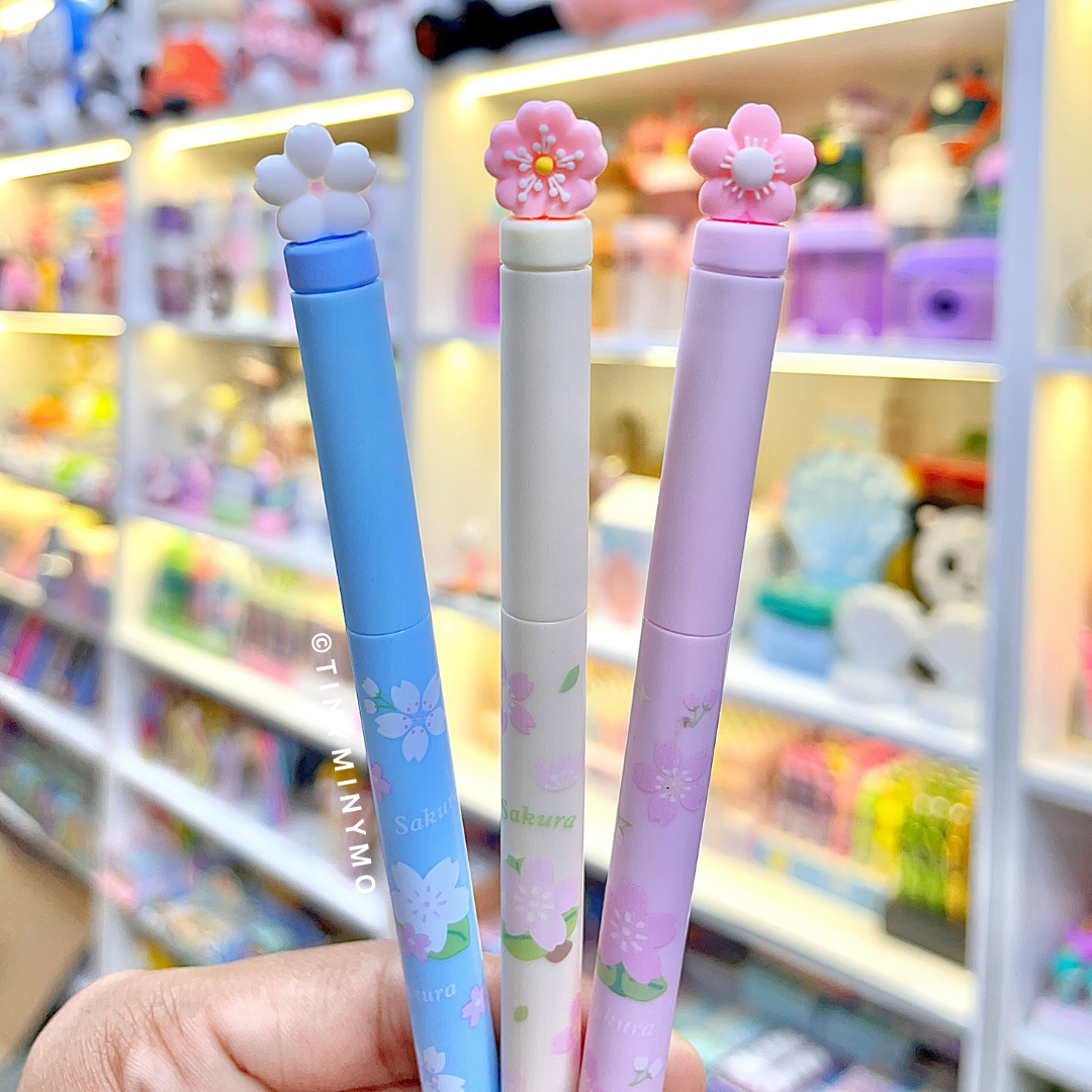 Three Sakura Gel Pen held in front of a store shelf - Tinyminymo